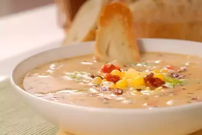 Bread being dipped in corn chowder.