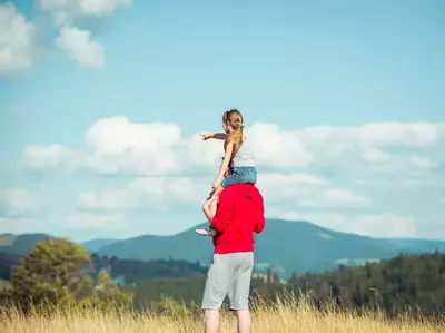 Father with daughter on his shoulders pointing at the Great Smoky Mountains near our affordable Pigeon Forge condo rentals